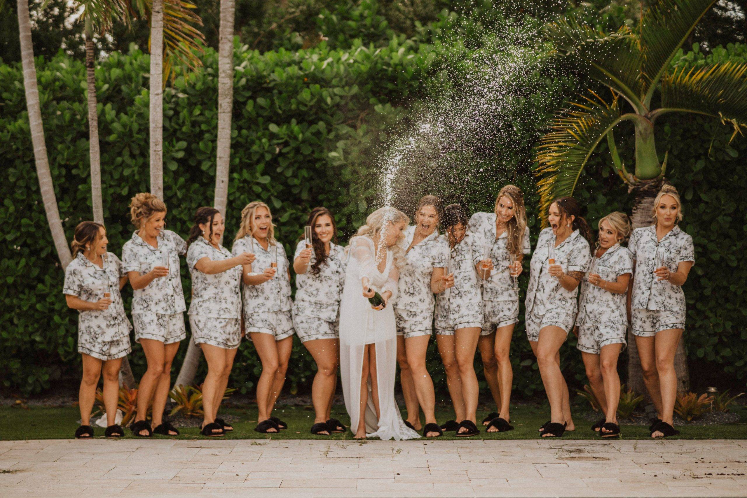 A bride popping champagne with all her bridesmaids in Jupiter, Florida