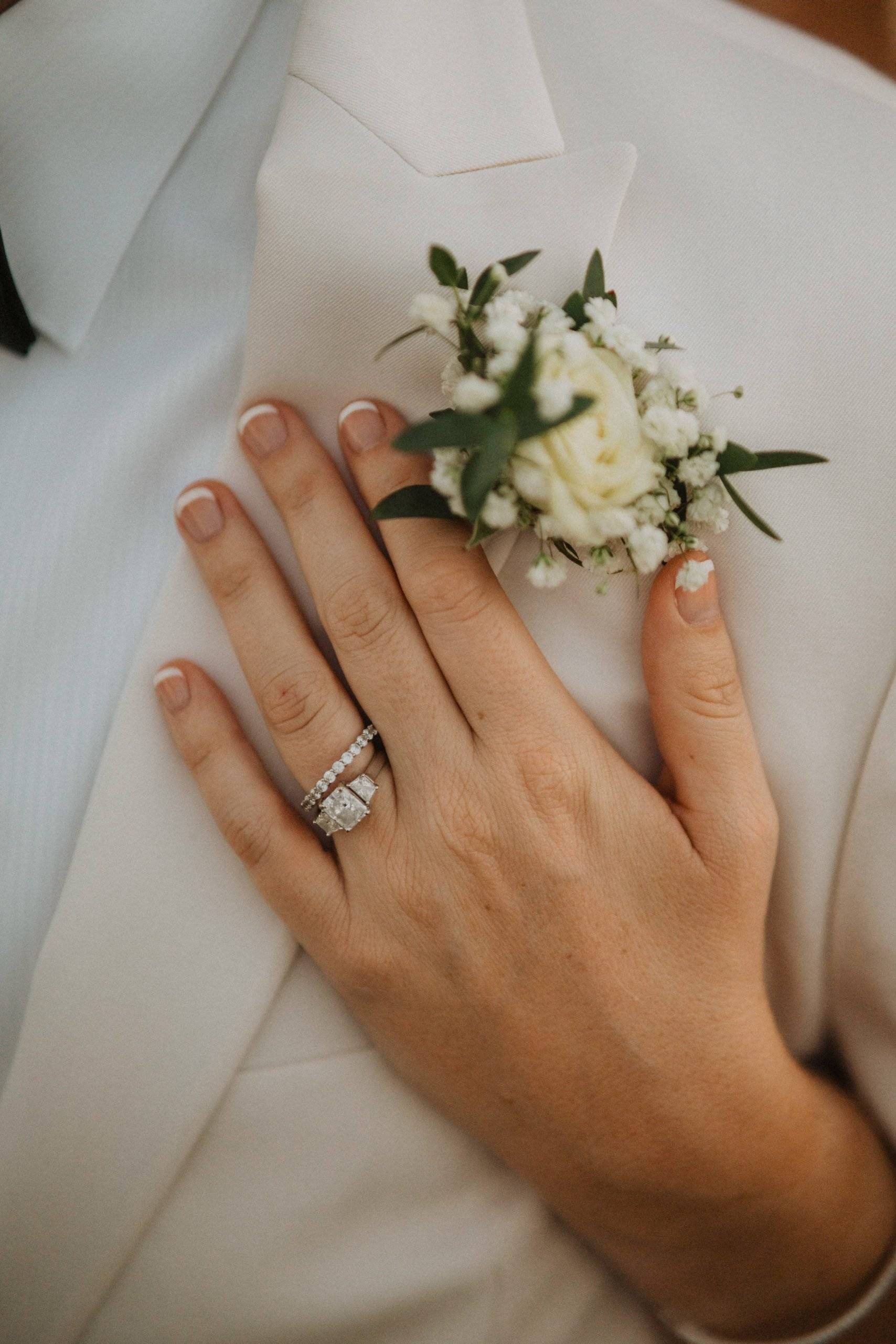 Image of brides hand on suit jacket with wedding band shown in Jupiter Florida