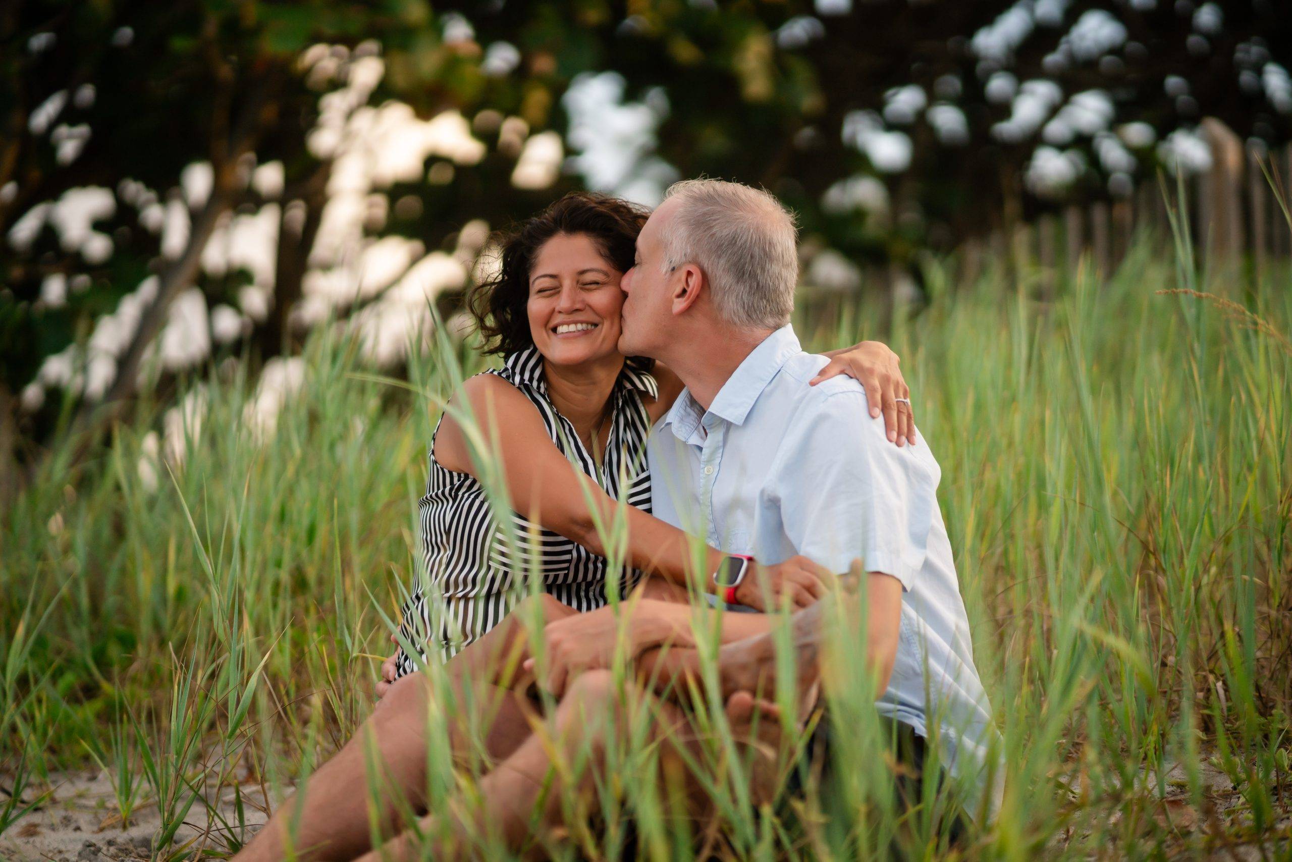 A couple recently engaged, sitting on a beach in Jupiter, Florida