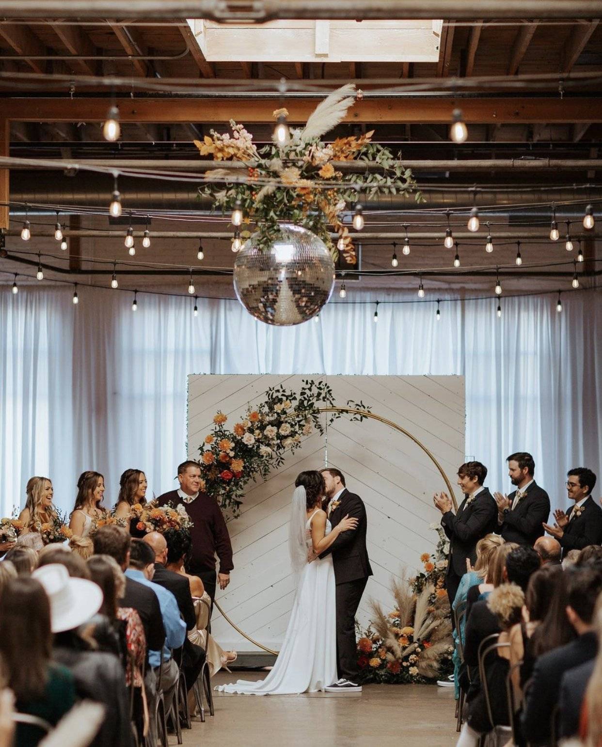 A bride and groom, kissing at the altar at skylight wedding venue in Denver, Colorado