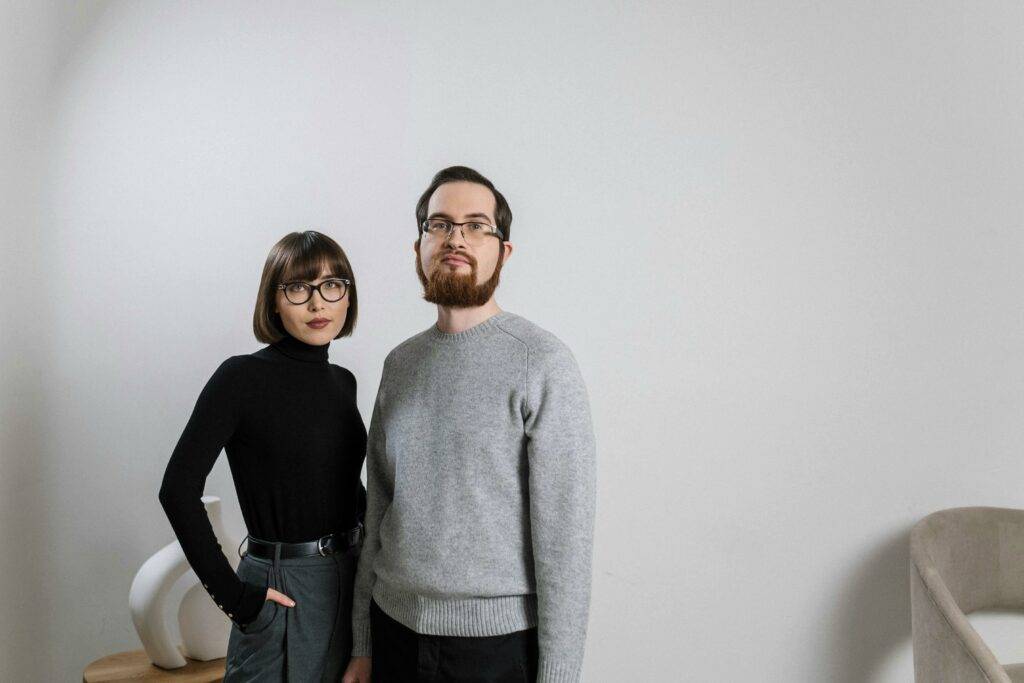 Lady and guy standing in front of a white wall