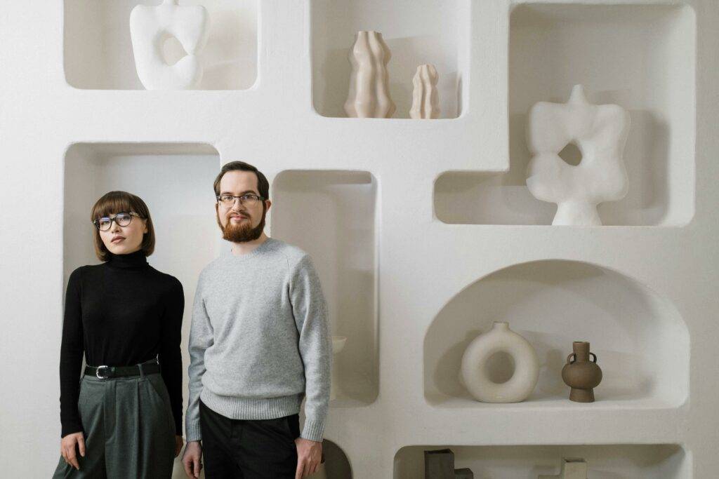 Lady and man standing in front of a white artistic wall 1